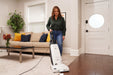 Woman using a vacuum cleaner in a living room.